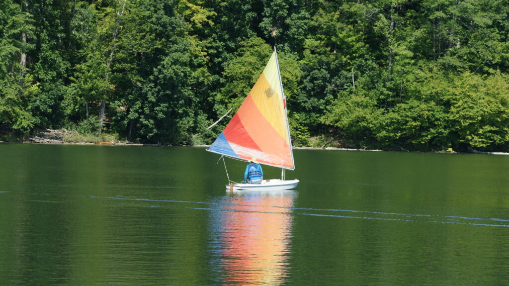 small colorful sailboat on lake